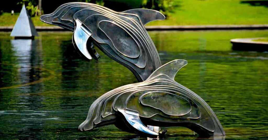Arquitectura de exhibición de dos delfines o bufeo saltando en las aguas